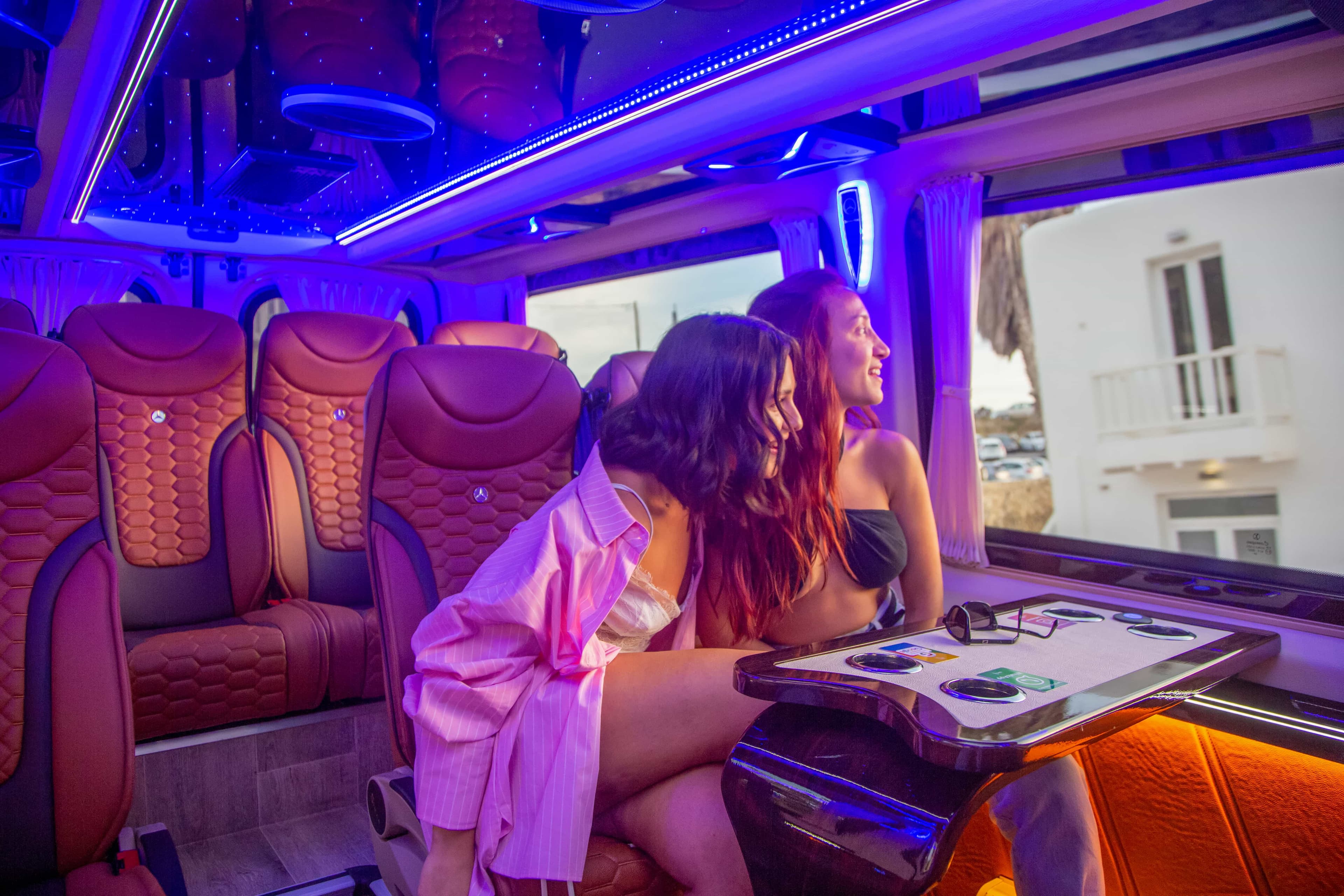 Friends celebrating inside a JMK Transfers party van in Mykonos